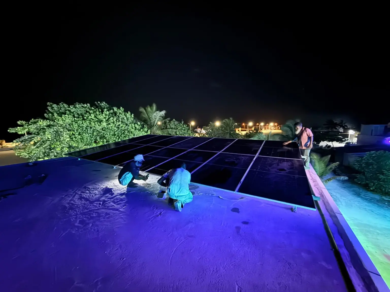 SQ Depot technicians installing rooftop solar panels at night